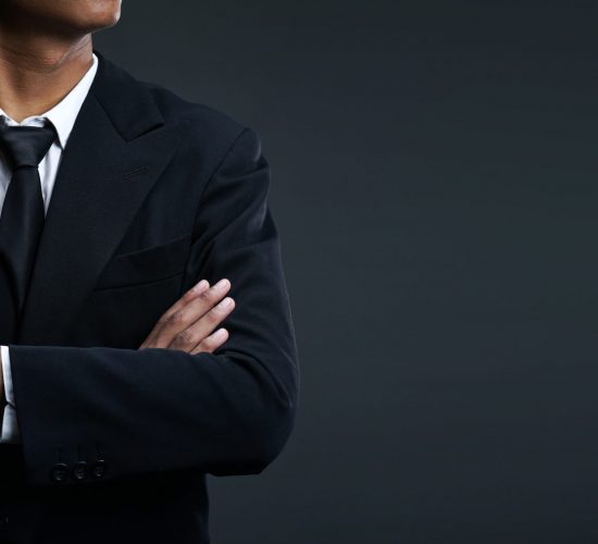 Asian Businessman Arms Crossed on Dark Background Copy Space